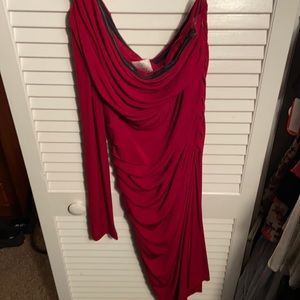 Knee length tight red dress. One long sleeve; other side strapless.